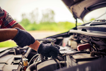 maintenance car using screwdriver. Traveler man hands holding tools fixing repair car engine. Close...