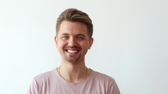 Portrait of a caucasian young handsome man looking at camera and laughing.