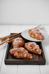 Almond croissant with custard filling on wood background.