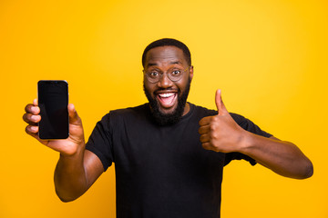 Great promo choose. Portrait of funny afro american man hold smartphone show thumb up sign advise...