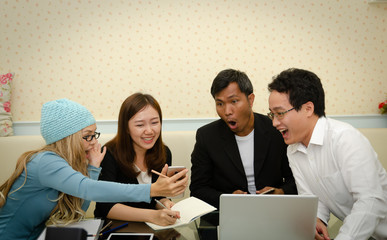 group of asian business people looking at the phone  and talking during meeting - 300648500