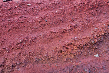 A cut of soil with rocks and red soil