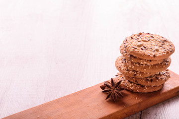 Cookies of sesame seeds, sunflower seeds and other spices on a wooden plate. Bright key