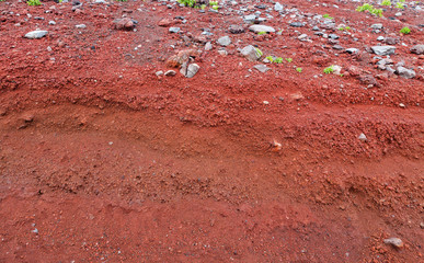 A cut of soil with rocks and red soil