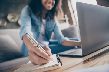 Cropped blurry focus photo of amazing dark skin curly lady browsing notebook writing pen plan list diary sitting cozy sofa wear casual denim outfit flat indoors - obrazy, fototapety, plakaty