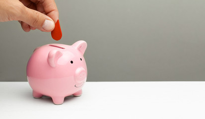 Blood donations. Man puts drop of blood in piggy bank. Copy space for text.