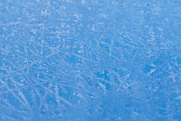The texture of the frosty patterns on a blue background.