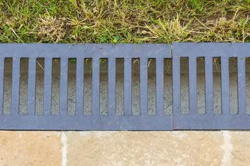 close-up of water drain gutter that separates the lawn from the paved terrace - flatlay