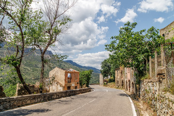 Fototapeta na wymiar Empty road in the mountains leading to abandoned old village Gairo Vecchio, destroyed by a flood and called Ghost Town. South Sardinia, Italy.