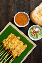 Pork satay - Grilled pork served with peanut sauce or sweet and sour sauce on Banana leaf - Asian food style on wood table