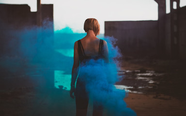 Attractive woman with a colorful smoke grenade bomb