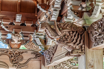 Wooden carving of elephant decorates the gable of a roof over the entrance of an ancient Buddhist temple in Japan.