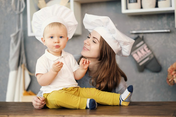 mother and child on kitchen, white hats of chef, relationships of mother and son