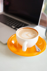 Hot capuchino coffee on table with notebook background. - 300664303