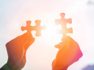 Autism and autistic ,child connect puzzle together. Hands of business holding pieces of jigsaw as a...