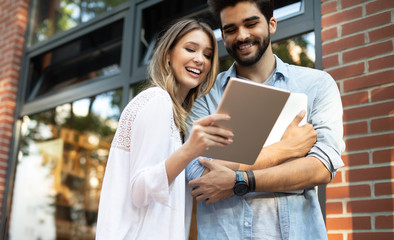 Travel, vacation, technology and friendship concept. Smiling couple with tablet in city