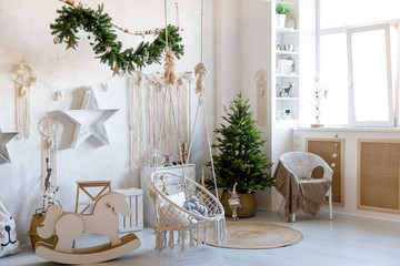 Modern interior design room with Christmas and New Year decorations, toys, gifts, fir tree, hanging swing. Winter holidays composition.
