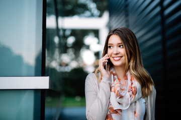 Beautiful woman using a smartphone on street. Social network, technology, busy life concept