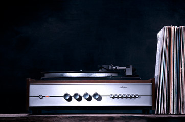 Vintage turntable and vinyl records on a black background.Retro style