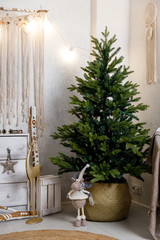 Modern interior design room with Christmas and New Year decorations, toys, gifts, fir tree, hanging swing. Winter holidays composition.