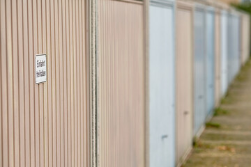 Row of garage doors with a sign on the first door that says 