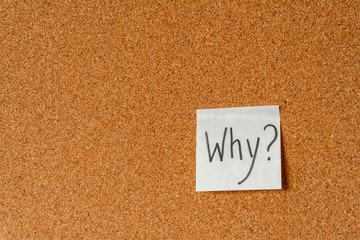 The question "Why" on a paper sticker on a cork board. Background. Copy space.