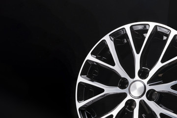 car alloy wheel black and white beautiful modern design, on a black background, close-up element, thin spokes