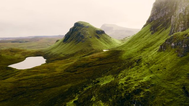Aerial shot of Scotland's green mountains and green wide plains at the Isle of Skye. Green landscape in Scotland.