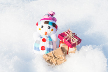 cheerful snowman with gifts in a snowdrift