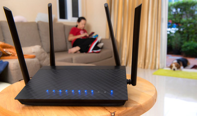 Selective focus wireless router and blur focus woman using phone on living room at home