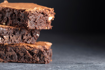 brownies chocolate three stacked on grey background extreme close up