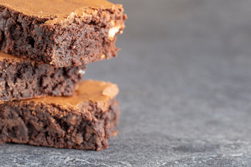 brownies chocolate three stacked on grey background extreme close up