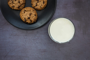 Milk cookies biscuits chocolate chip top view dark background