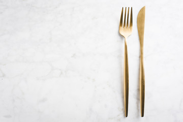 Gold cutlery set on marble background