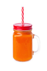 Closeup glass jar of orange color smoothie isolated at white background. Concept of healthy vegan food