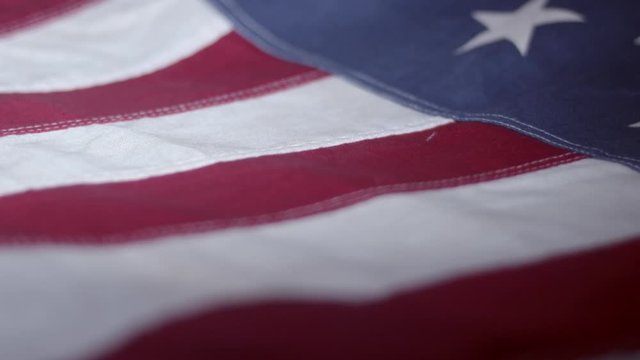 Smooth pan along outspread American flag, extreme close-up