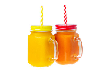 Two closeup glass jars of orange and yellow color smoothies with mango and papaya isolated at white background. Healthy vegan superfood lifestyle, detox dieting.