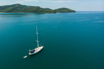 Obraz na płótnie Canvas Aerial view of white Yacht in deep blue sea with beautiful landscape view in Kuala Abai, Kota Belud, Sabah, Malaysia