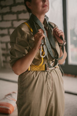 Beautiful girl in overalls holds mounting belt