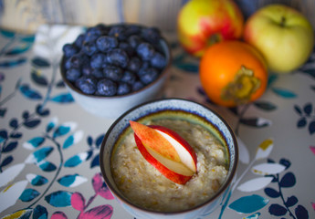 Bowl of oatmeal porridge with blueberry on  table. Healthy breakfast and diet food