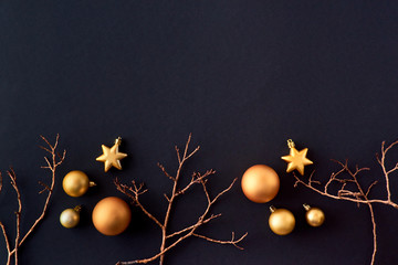 Flat lay border with gold christmas balls and branch on a dark background