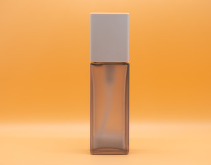 Cosmetic bottles face cream, dark brown, to wipe the face for cleanliness. On an orange background, isolated