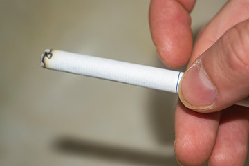Cigarette in a man's hand concept photo. The dangers of Smoking. Healthy lifestyle. Rejection of bad habits.