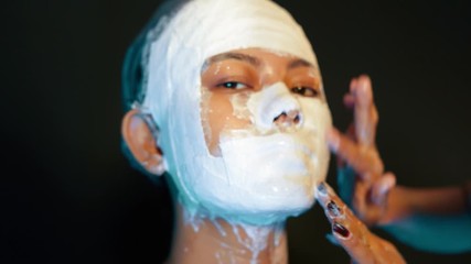 Plaster prosthetic process by a makeup artist on a waiting model, closeup 
