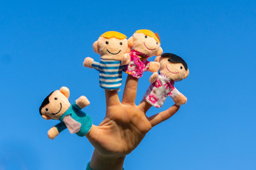 family finger dolls. child hand with finger puppets: son, daughter,mum, dad. Kid playing fingers...