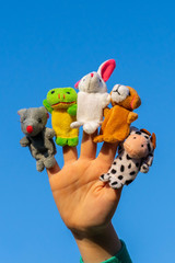 child hand with finger dolls: cow, frog, dog, rabbit, mouse, hare. animal finger puppets show and...
