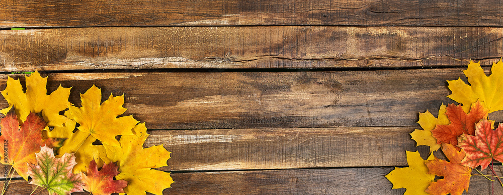 Wall mural autumn maple leaves on top view wooden table. horizontal frame with two bottom corner.
