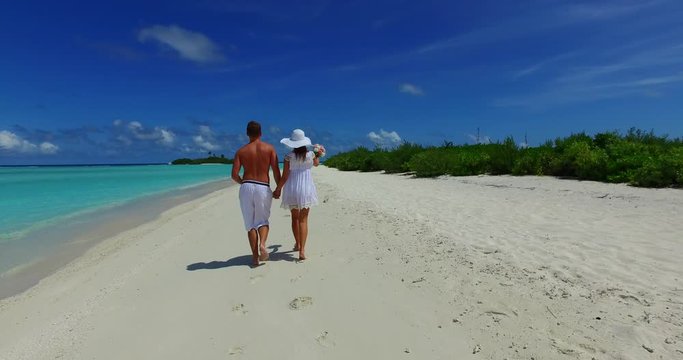 Happy Hand-held Couple Running On Long White Beach In Thailand, Girl With White Hat Holding A Roses Bouquet