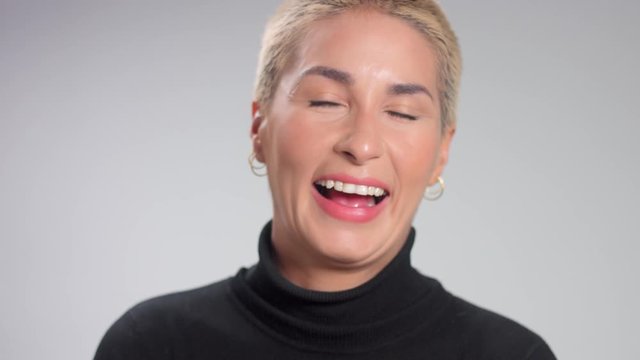 happy natural laughing caucasian woman with short hair style in studio alone