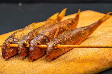 Dried mullet on a wooden Board on the table. Fish and seafood cuisine. Tasty snack. Close up.